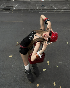 Woman in a bandana and sunglasses posing on a street