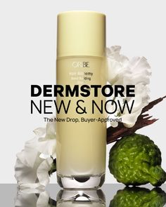 Oribe hair product with white flowers, bergamot, and wood on a reflective surface