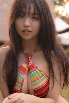 Woman with long hair wearing a striped bikini top outdoors