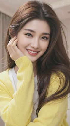 Woman with long brown hair wearing a yellow cardigan, smiling at the camera