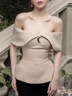 Woman in an off-shoulder beige top with a moon pendant and earrings