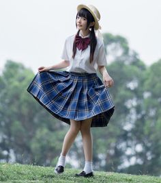 Young woman in a school uniform and straw hat posing outdoors