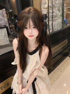Person with long brown hair and a ruffle dress with black ribbons