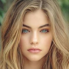 Close-up portrait of a woman with blonde hair and striking blue eyes