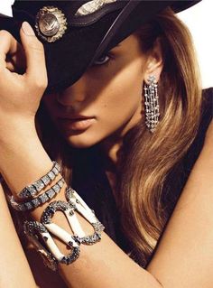 Woman in a cowboy hat with long hair and elaborate jewelry