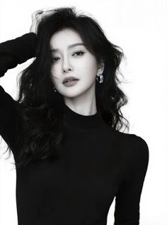 Woman with long black hair wearing a black turtleneck in a black and white portrait