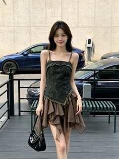 Woman with long hair wearing a denim top and ruffle skirt outdoors