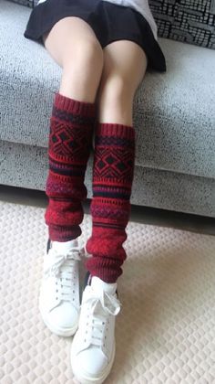 Person wearing red patterned leg warmers, white sneakers, and a short skirt