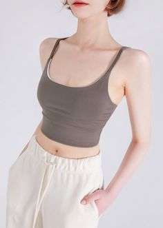 Woman in a crop top and sweatpants with hands in pockets