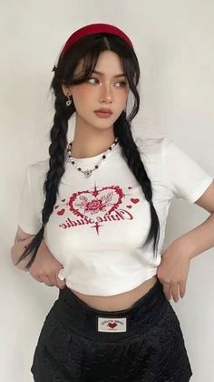 Woman with black braids and a red headband wearing a white crop top and black shorts