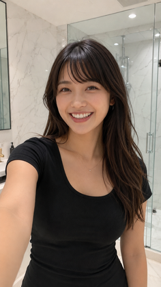 Woman with long dark hair smiling in a bathroom