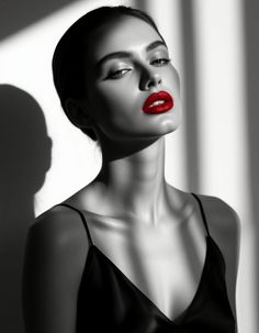 Woman with red lipstick in a black and white portrait with dramatic lighting