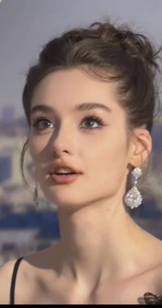 Woman with an updo and large earrings in soft outdoor lighting