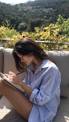 Woman with long hair drawing outdoors in a striped shirt