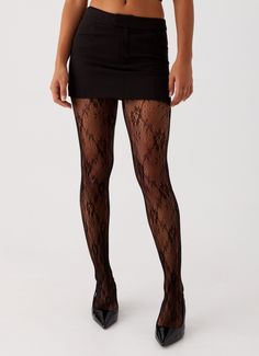 Person wearing a black mini skirt, lace tights, and high heels