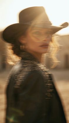 Woman in a cowboy hat and leather jacket with motion blur and golden hour backlight