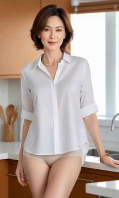 Woman in a white shirt and underwear posing in a kitchen