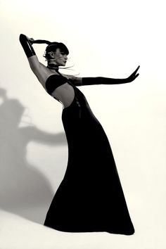 Woman in a black latex dress and futuristic headpiece posing dramatically