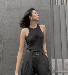 Woman with short hair and black outfit standing outdoors