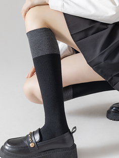 Person wearing knee-high socks, a pleated skirt, and loafers