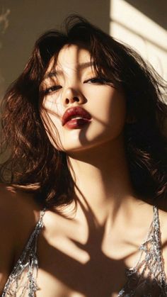 Woman with dark lipstick and a sparkly top in dramatic lighting