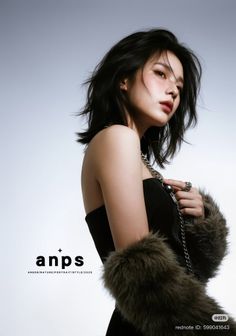 Woman with short black hair wearing a strapless top and fur sleeves, holding a silver chain