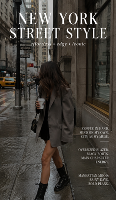 Woman in an oversized blazer and black boots walking on a rainy city street