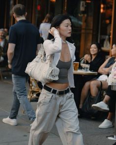 Woman in a crop top and baggy jeans walking on a street