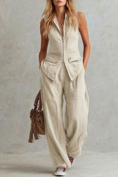 Woman in a light-colored linen sleeveless top and wide-leg pants with a brown bag