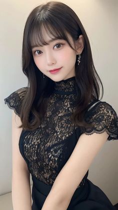 Woman with long dark hair wearing a black lace dress and earrings