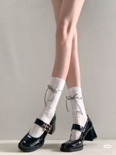 Person wearing black mary jane shoes with white socks and bows