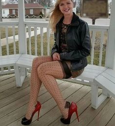 Woman in polka dot stockings and red high heels sitting on a bench