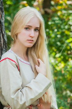 Woman with long blonde hair in an embroidered dress outdoors