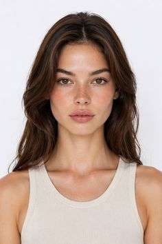 Woman with long brown hair and freckles wearing a tank top