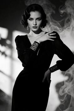Woman in a black dress with vintage hairstyle and jewelry in dramatic lighting