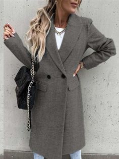 Woman in a long gray coat with a black handbag and blonde ponytail