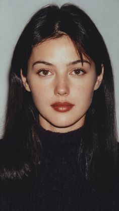 Woman with long dark hair and dark lipstick wearing a turtleneck sweater