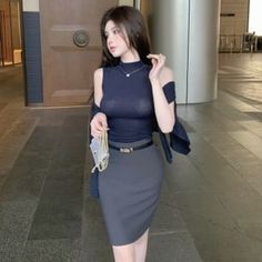 Woman with long hair in a sleeveless top and pencil skirt indoors