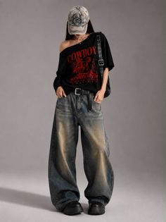 Person in an oversized t-shirt, baggy jeans, and a baseball cap in a studio