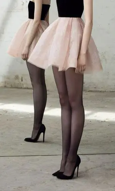 Person in a black top and pink tutu skirt with black pantyhose and high heels