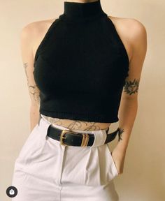 Person in a black halter top and white pants with a black belt