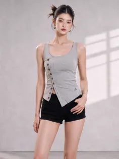 Woman in a grey tank top and black shorts posing indoors
