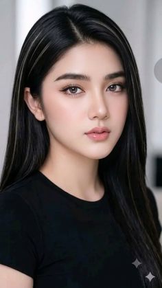 Woman with long black hair and light eyes wearing a black shirt
