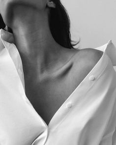 Upper body of a person in a white shirt with an exposed shoulder