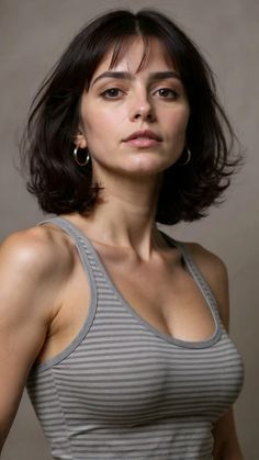 Woman with short dark hair and hoop earrings wearing a striped tank top