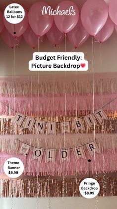 Pink and gold party decorations with balloons, fringe, and a banner