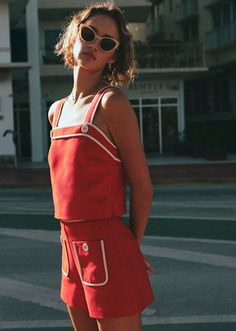 Woman in a red top and shorts with sunglasses outdoors