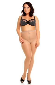 Woman in a black bra and nude tights posing in a studio