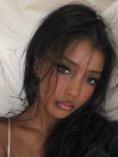 Woman with long dark hair and natural makeup in a close-up portrait