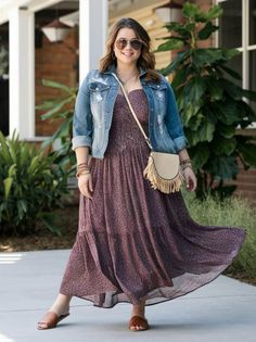 Woman in a maxi dress and denim jacket posing outdoors